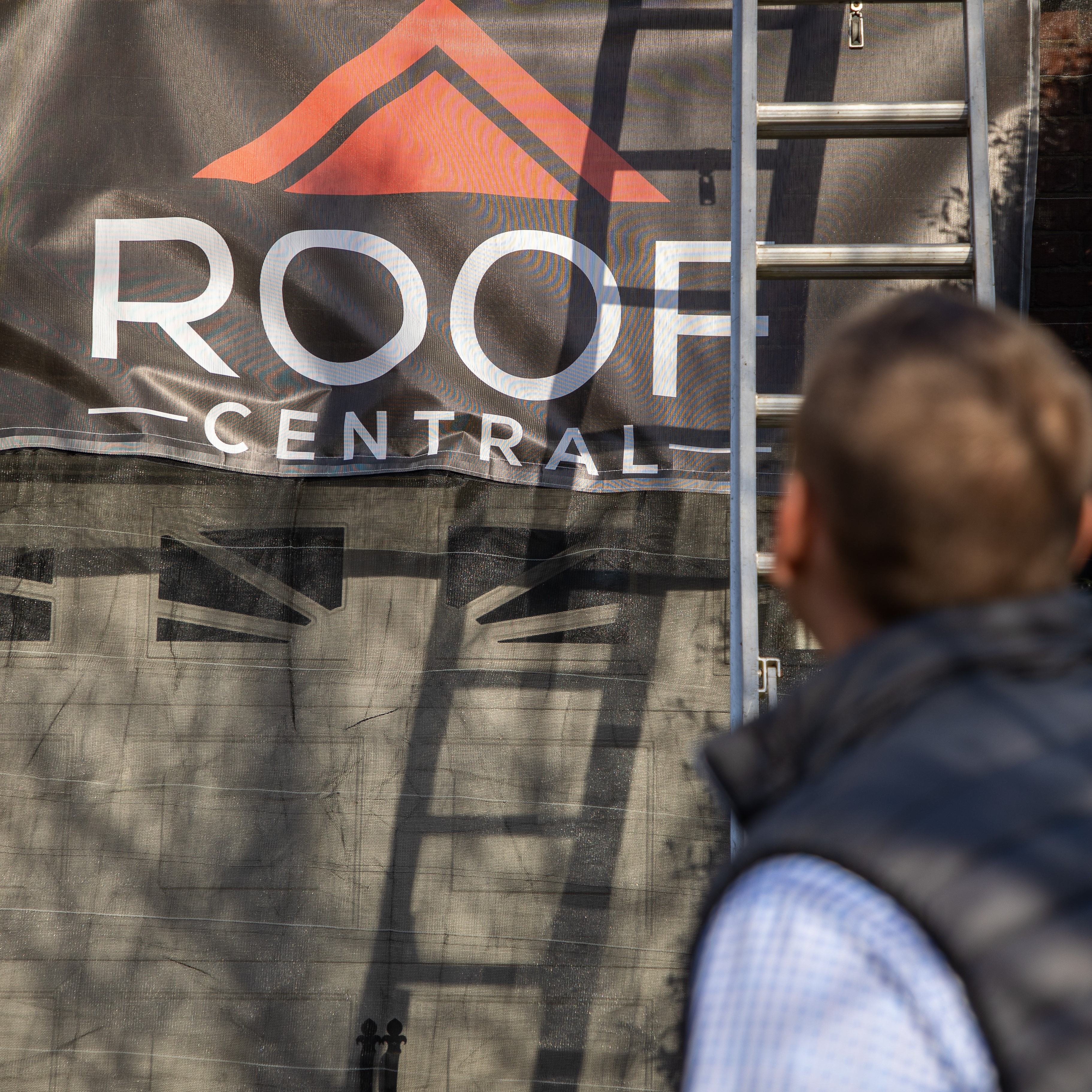 A roofer securing the area to start a roof inspection.