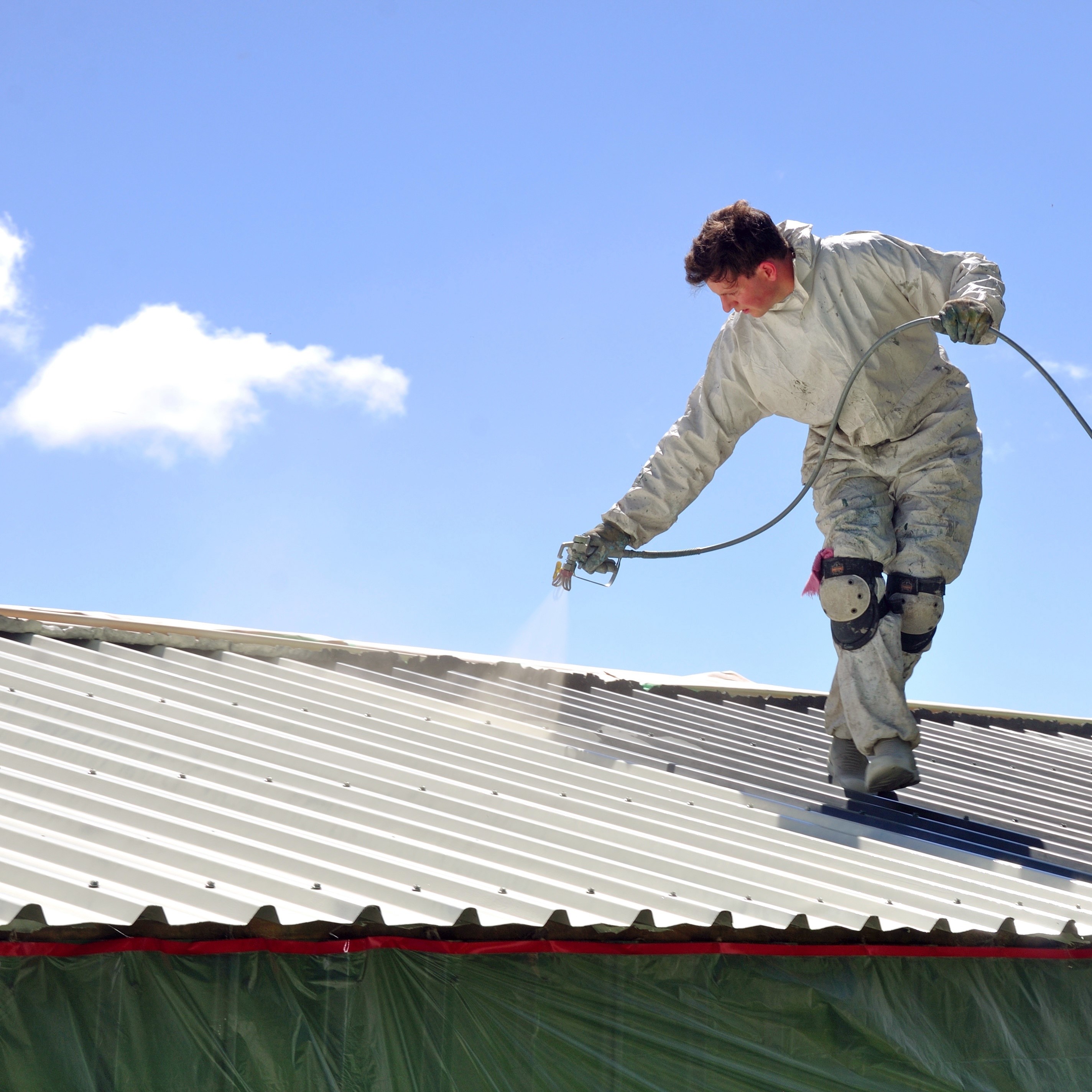 Spraying silicone coating on a roof.